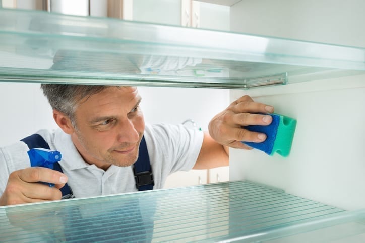 man cleaning fridge