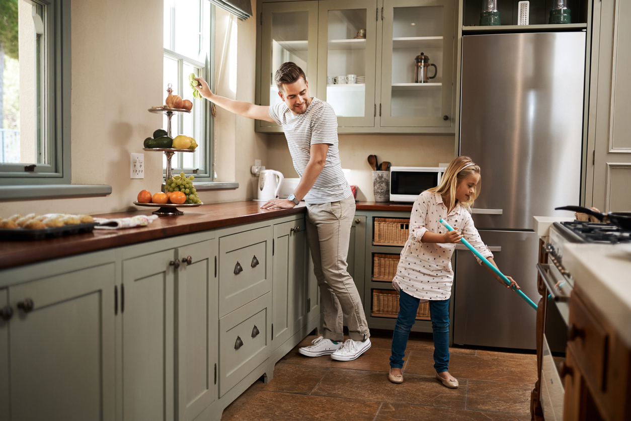 father and daughter cleaning the kitchen