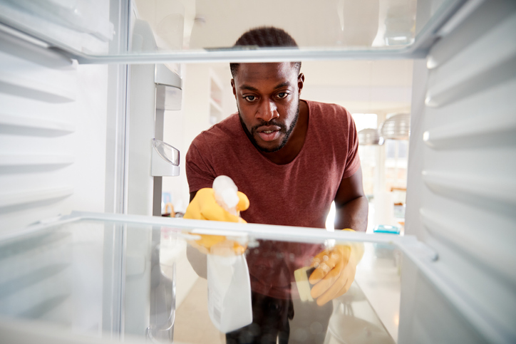 man cleaning his fridge